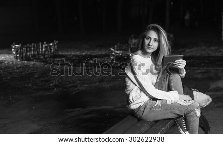 Black and White. BW. Young woman sitting with Tablet and reading from ebook