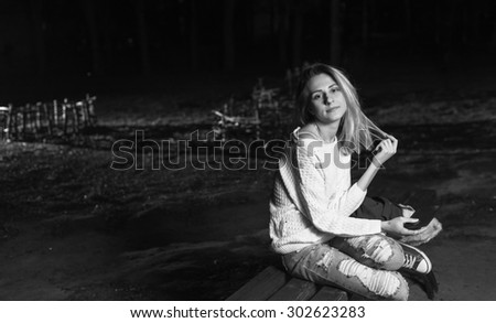 Black and White. BW. Young woman sitting with Tablet and reading from ebook