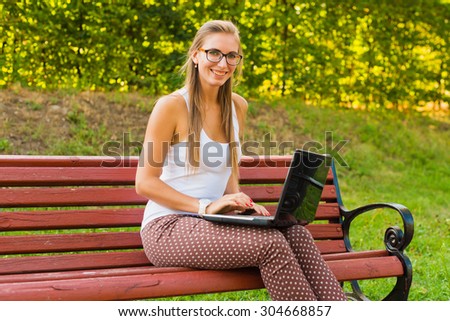 Young woman using tablet, laptop, notebook, reading books outdoor, smiling.