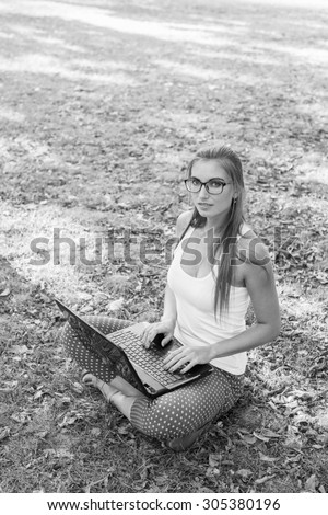 Black and White. Young woman using tablet, laptop, notebook, reading books outdoor, smiling.