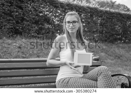 Black and White. Young woman using tablet, laptop, notebook, reading books outdoor, smiling.
