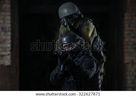 Fully equipped military men with automatic weapons playing in  airsoft strikeball
