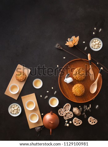 Flat lay mid autumn festival food and drink on rustic black background. Text space image.