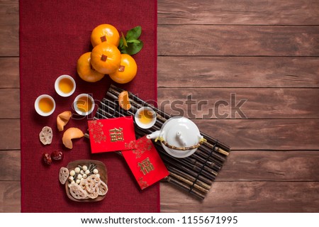 Flat lay Chinese new year food and drink on wooden table top. Texts appear in image: Prosperity, Spring. Text space image.