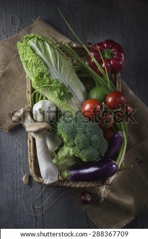 Fresh vegetables in basket on rustic kitchen counter top.