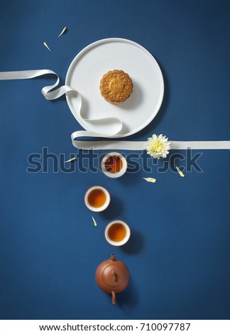 Conceptual flat lay mid-autumn festival moon cake food and drink on blue background.\
Translations on text appear in image: Mid-autumn.