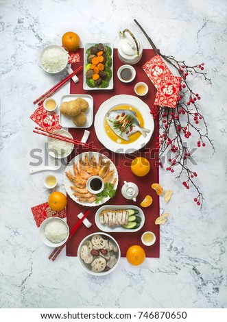Flat lay Chinese new year reunion dinner food and drink still life. Marble table top. Text appear in image