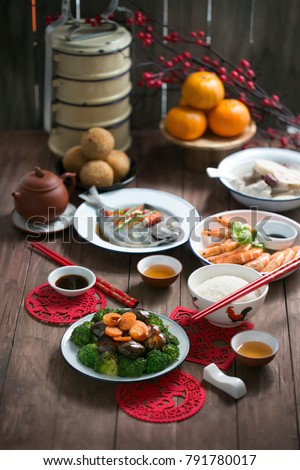 Text appear in image: Prosperity. Chinese new year food homecooked reunion dinner on wooden table top.