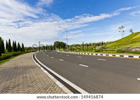 Long and Clear Road in the Public Park with White Cloud and Blue Sky.