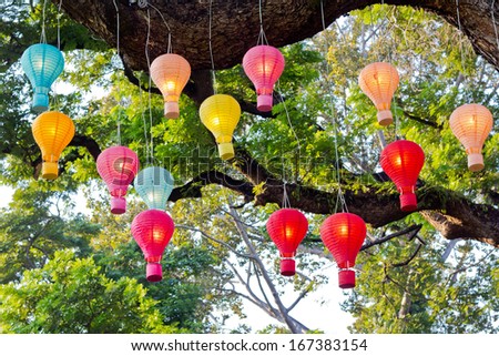 Electric Lanterns in balloon-shape, hanging on the big tree.