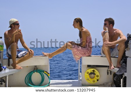 Three Divers relax on a Dive Boat during the Surface Interval