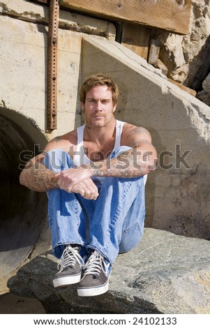 Man with Tattoos sitting looking at the camera