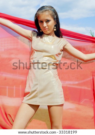 The young girl in golden dress with red scarf