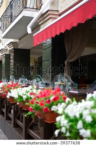 Outside terrace of restaurant with floral lawns. Shallow DOF