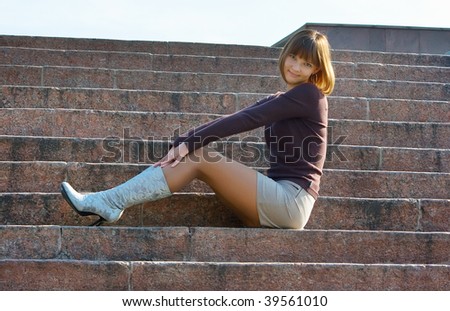 The romantic girl sitting at ladder steps. Outdoor, park