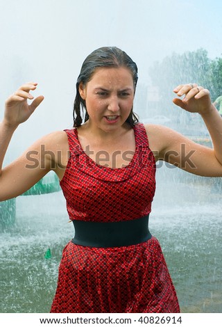 The young girl in wet clothes in a city fountain