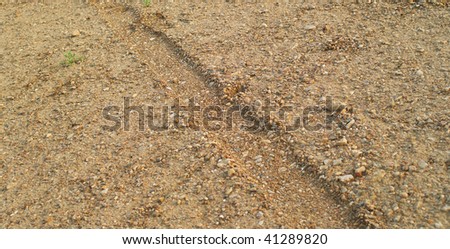 Traces from wheels on stony soil. Natural background