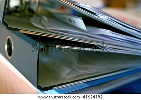 The stack of full ring binder files. Shallow DOF