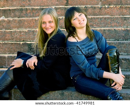 The romantic girls sitting at ladder steps. Outdoor, park