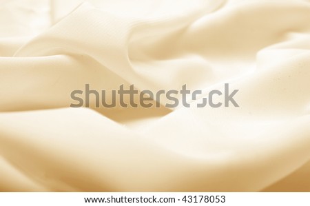Abstract background beige silk fabric with waves. Shallow DOF