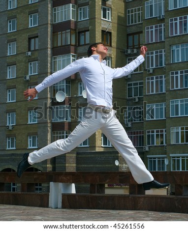 Young happy men jumping against urban landscape