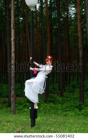 stock photo The young beautiful bride in a wedding dress against pine wood