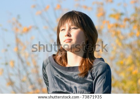 Portrait of the sad asian girl against autumn abstract background. Shallow DOF
