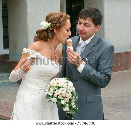 Portrait of the bride and groom with ice-cream. Shallow DOF