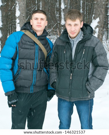 Two serenity mens against winter landscape wirh pines.