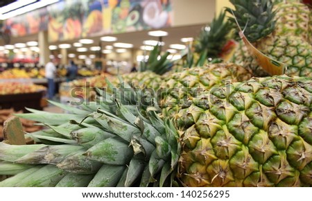 Side view of pineapples with spiky tops at the supermarket.