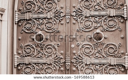Gorgeous detail of scroll work and door knockers on imposing doors that may or may not invite one inside.