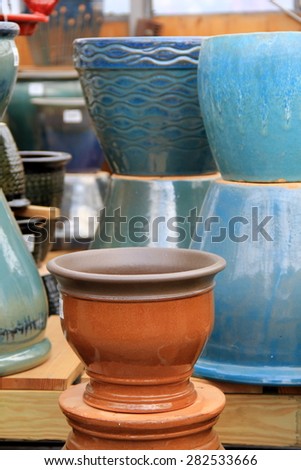 Large clay pots with colorful glaze that brighten them up, set together for sale at local shop