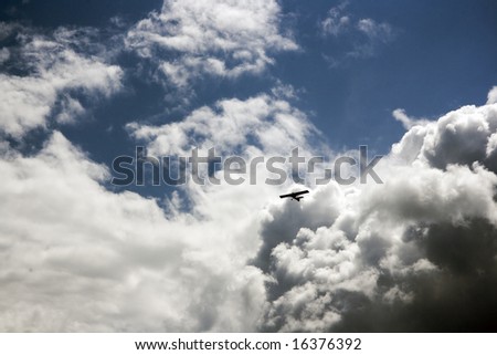 An airplane flying in the blue cloudy sky, horizontal image