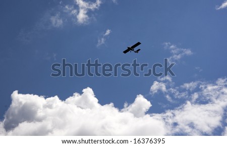 An airplane flying in the blue cloudy sky, horizontal image