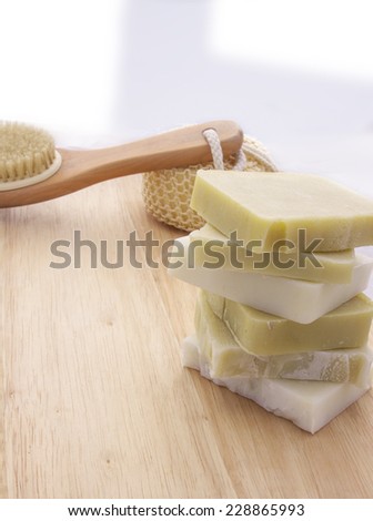 White and Green Handmade Soap on a wooden background with bath supplies