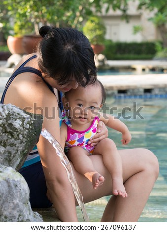 Picture of mother and daughter playing by pool side