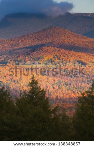 Fall foliage landscape with Trapp Family Lodge and Mt. Mansfield in the background, Stowe, Vermont, USA