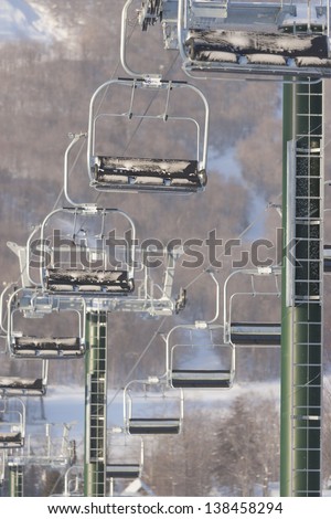 Empty triple chair lift with a ski mountain in the background, Stowe, Vermont, USA