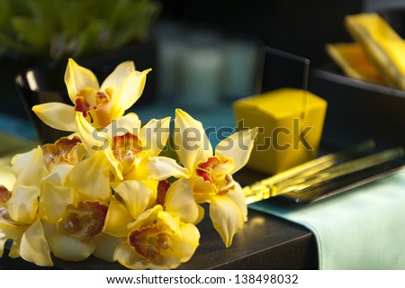 A bouquet of yellow lilies laying on a block of stone.
