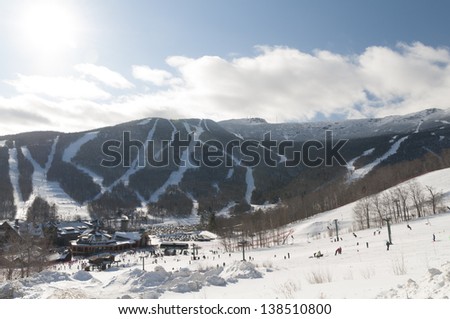 Spruce Peak Lodge in the winter with Mt. Mansfield in the background, Stowe, Vermont, USA