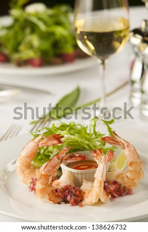 A fancy shrimp cocktail appetizer in a restaurant setting.