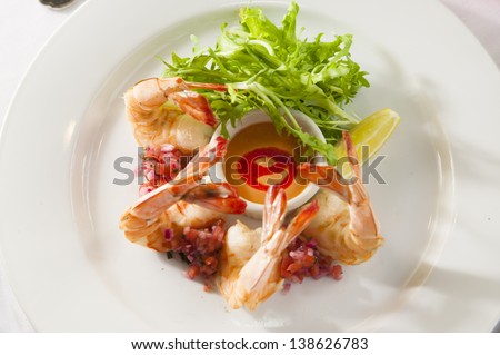 A fancy shrimp cocktail appetizer in a restaurant setting.