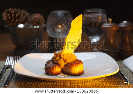 Restaurant served fried scallops on a white plate.