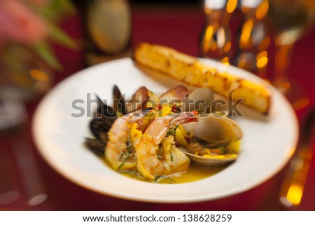 Restaurant served grilled seafood appetizer on a white plate.
