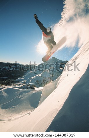 Snowboarding Off A Cliff Off Piste On A Sunny Day In Donner Pass, California, Usa