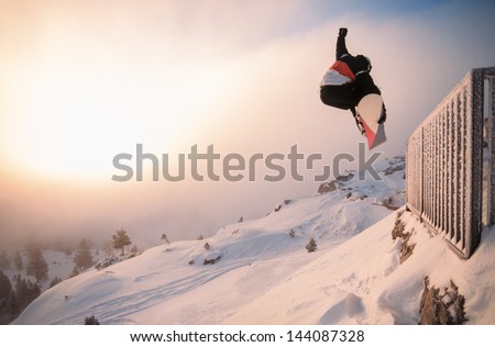 Snowboarding Off A Cliff Off Piste On A Sunny Day In Donner Pass, California, Usa