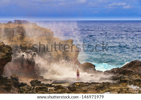 Tourists looking at a blow hole on the Maui coastline, Hawaii, USA