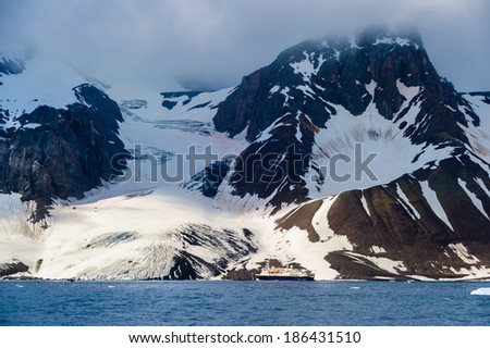 HORNSUND, SVALBARD,NORWAY - JULY 26, 2010:  National Geographic Explorer cruise ship in front of a glacier in the Arctic Ocean.
