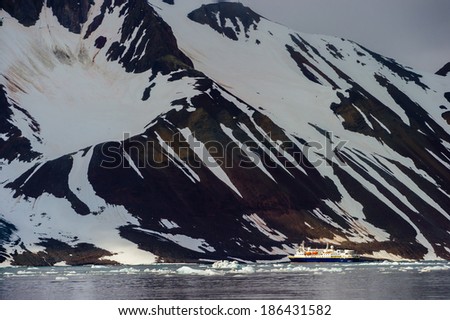 HORNSUND, SVALBARD,NORWAY - JULY 26,  2010:  National Geographic Explorer cruise ship in front of a glacier in the Arctic Ocean.