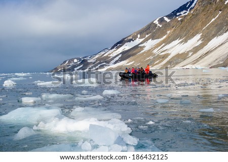 HORNSUND, SVALBARD,NORWAY - JULY 26, 2010: Tourists from the National Geographic Explorer cruise ship on inflatable rafts in the Artic Ocean exploring a fijord in the Arctic.